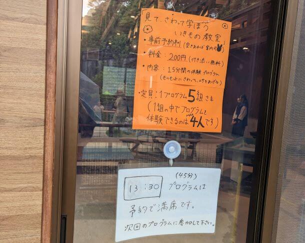 沖縄県沖縄市胡屋にある動物園「こどもの国沖縄ズージアム」の「見てさわって学ぼういきもの教室」の入口の画像。プログラムの料金と内容、定員について書かれてある。