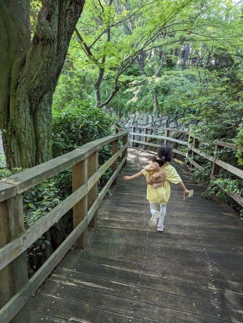 福岡県北九州市にある到津の森公園内の緑地を女の子が走っている画像