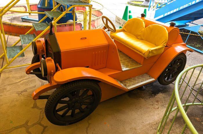 福岡市動物園の南園に位置する遊戯施設「ミニ遊園地」の遊具、オレンジ色のレトロカーの乗り物