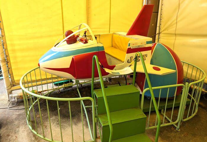 福岡市動物園の南園に位置する遊戯施設「ミニ遊園地」の遊具、飛行機の乗り物。日の丸のマークがツバサについている。